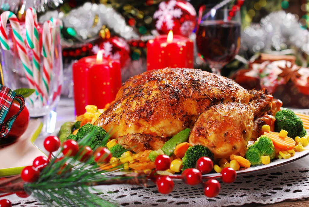 roasted whole chicken with colorful vegetables on christmas table